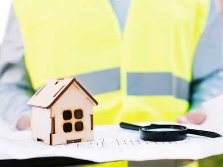 Rechtsschutzversicherung beim Hausbau prüfen – Modellhaus und Bauunterlagen zeigen, warum der richtige Versicherungsschutz vor Baubeginn wichtig ist.