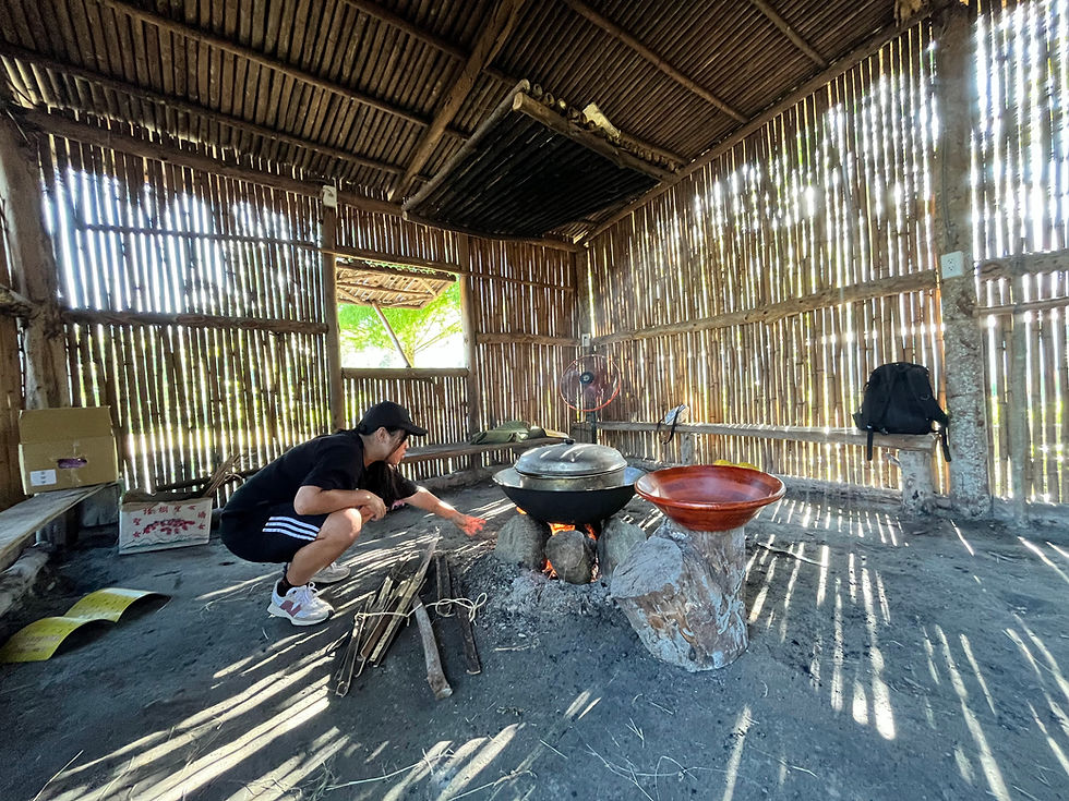 A traditional bamboo house of the Truku (Taroko) tribe in Taiwan. A youth is seen heating banana leaves over a fire.