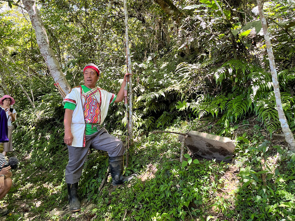 Elder Bunun tribe member in Taiwan teaches guests on a sustainable hunting tour how to use a hunting trap