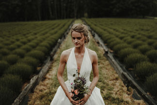 A+C's west coast island wedding at Bilston Creek Farm was a stunning celebration that embraced the moody atmosphere of the surroundings in all the right ways. With dramatic rain and a lush forest as their backdrop, the couple took full advantage of the picturesque property, resulting in breathtaking photos that captured the essence of their special day. Their outdoor ceremony was held beneath a magnificent tree, creating a magical setting that was both intimate and enchanting. The reception, located in The Barn, was designed with simplicity and elegance in mind, featuring rustic wooden tables, stylish black metal chairs, and beautiful fresh evergreens, all working together to enhance the natural beauty of the venue.