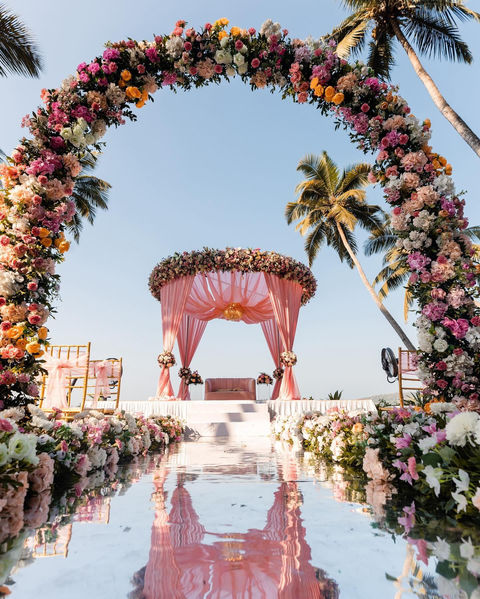 Semi Circular floral archs with Acrylic Pathway by the beach in Goa with Circular Overlay on Mandap