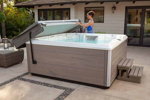 Woman easily opening a Hot Spring® spa cover using a CoverCradle II® cover lifter.