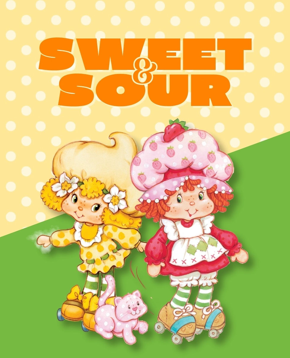 A girl in pink and a girl in yellow in roller skates standing behind a cat.