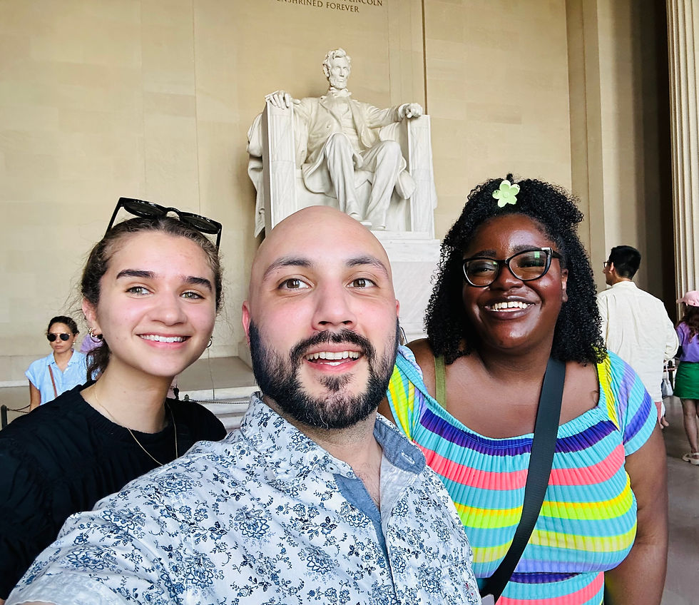 Three smiling people stand in front of the Lincoln Memorial statue in Washington DC
