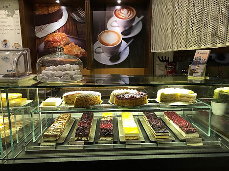 Kuchentheke mit Torte und Stückchen