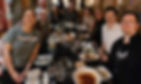 Photo of nine people around a dinner table.