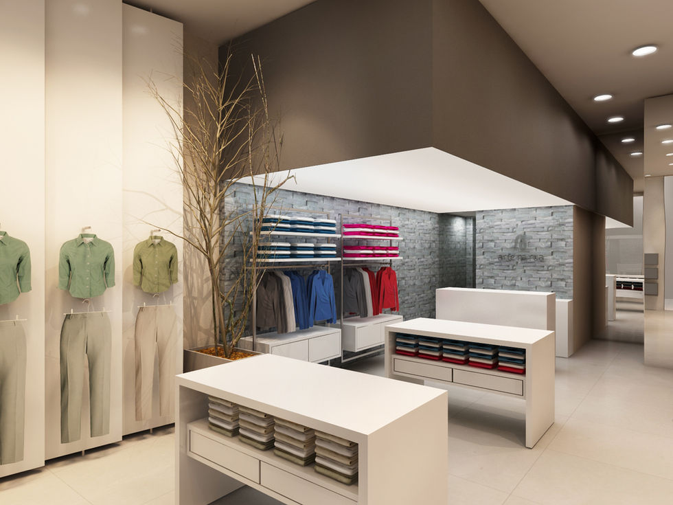 Interior de loja de roupas com balcões brancos e araras.