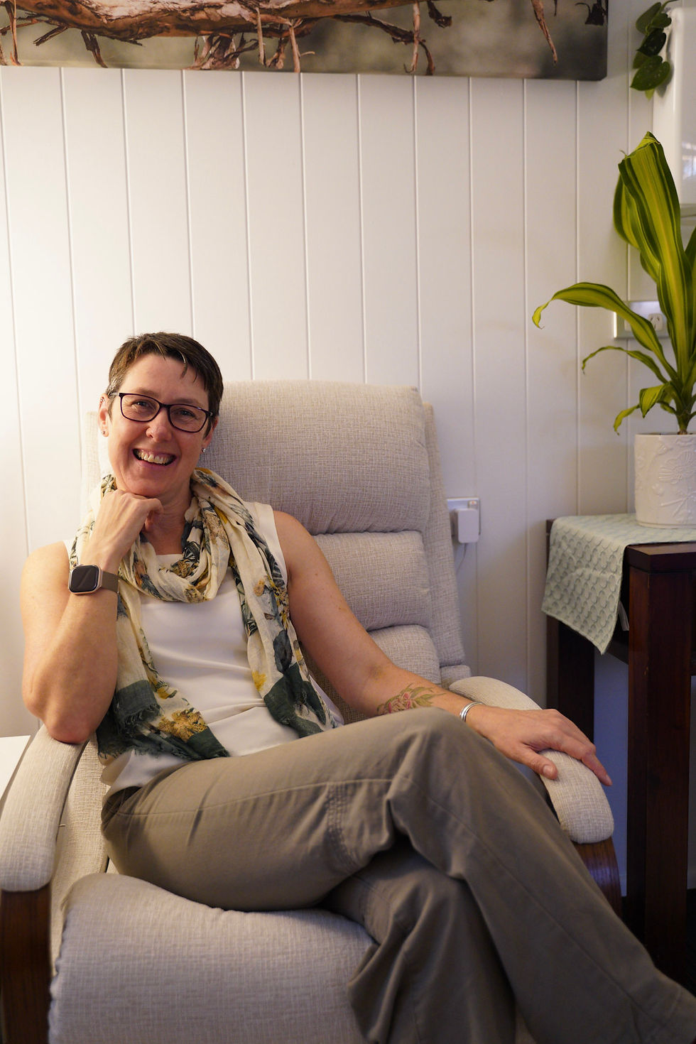 Smiling woman sitting in a chair for therapy in Brisbane.