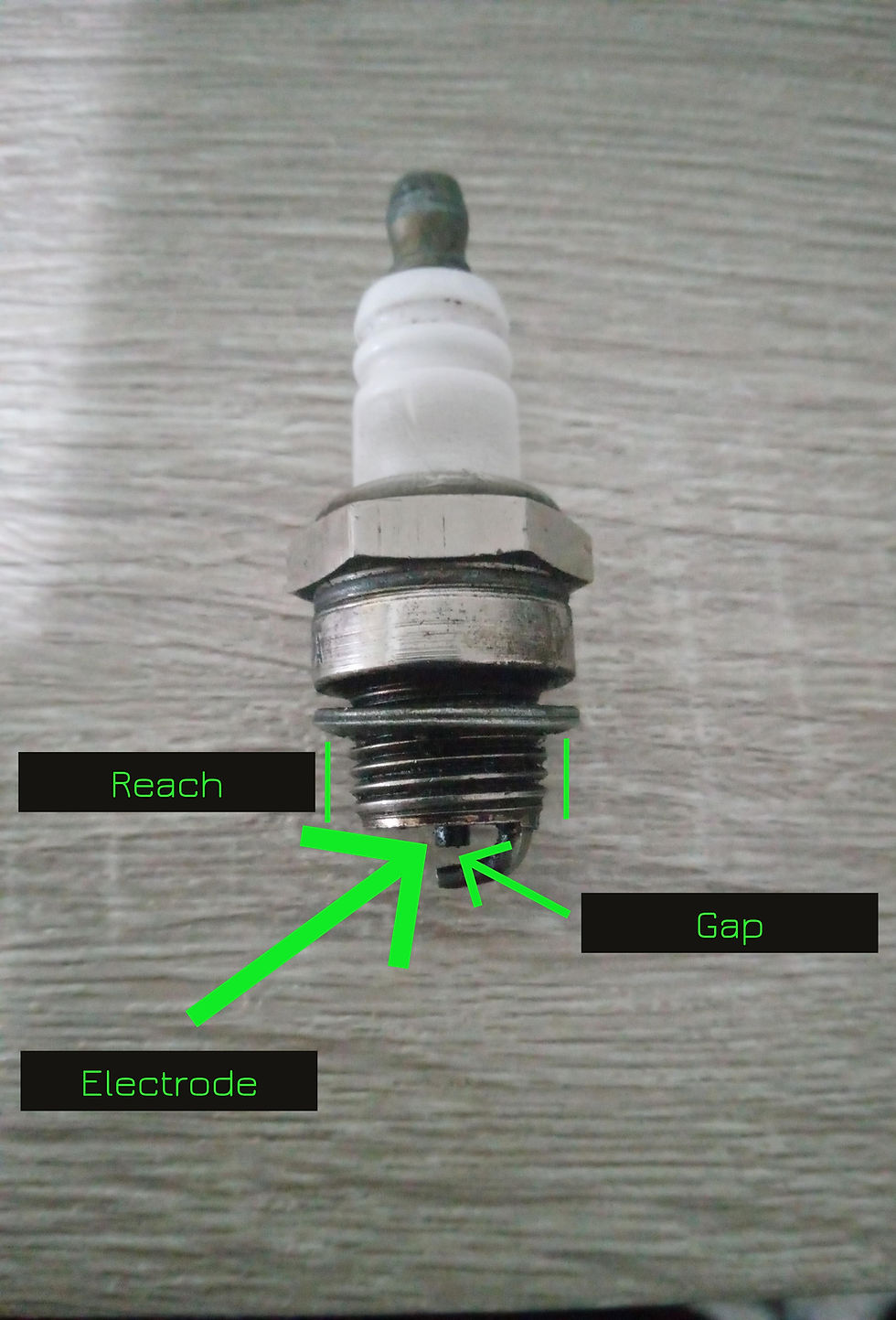 Lawn mower spark plug with reach, electrode and gap labeled
