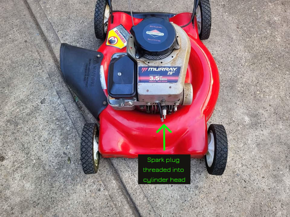 lawn mower spark plug threaded into cylinder head