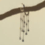 Un pendiente dorado con cadenas y adornos. BOA ACCESORIOS. Elegante y moderno diseño.