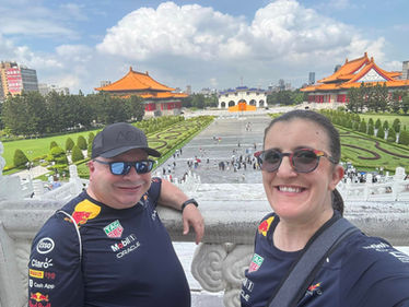 Happy couple poses near the beautiful landmark with blue sky background.