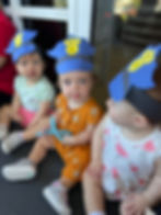 Three babies wearing police hats sitting together, featuring All Kids Academy.