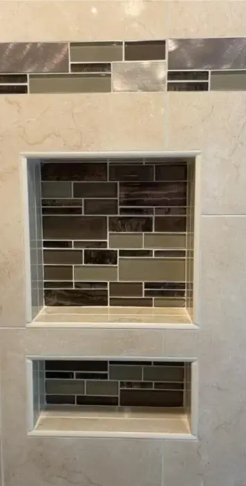 Two tiled shower niches with mosaic inlay