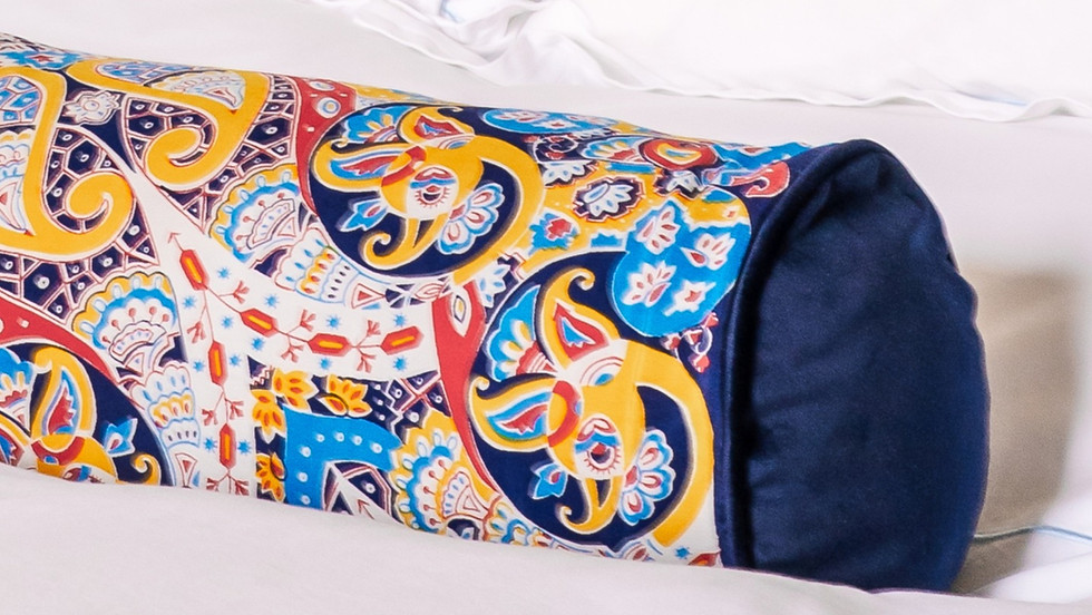 yellow red and blue bolster cushion with navy blue trim detal
