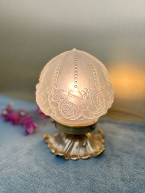 Lampe ancienne avec globe en verre aux motifs de roses et pied en bronze.
