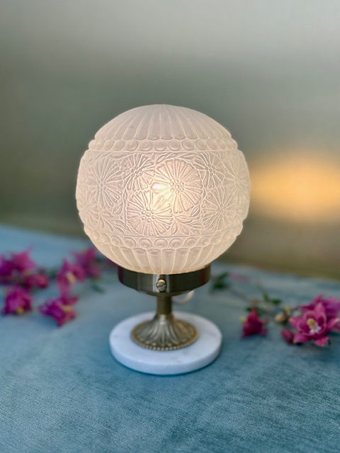Lampe art deco avec globe en verre aux motifs de fleurs et pied en laiton et marbre blanc.