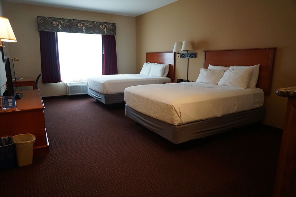 Standard hotel room with two queen beds and a window.