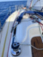 "Velero blanco navegando en mar abierto bajo el cielo despejado, disponible para alquiler privado"