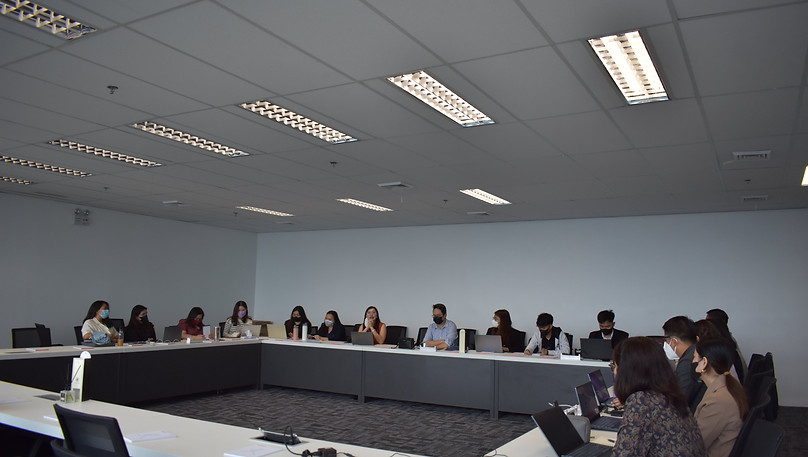 Enterprise team meeting in a large boardroom, with participants collaborating at a U-shaped table.