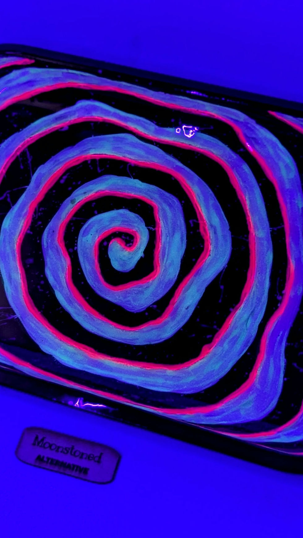 View of the "Altered State" Neon Hand-painted rolling tray under blacklight showing the neon pink glowing