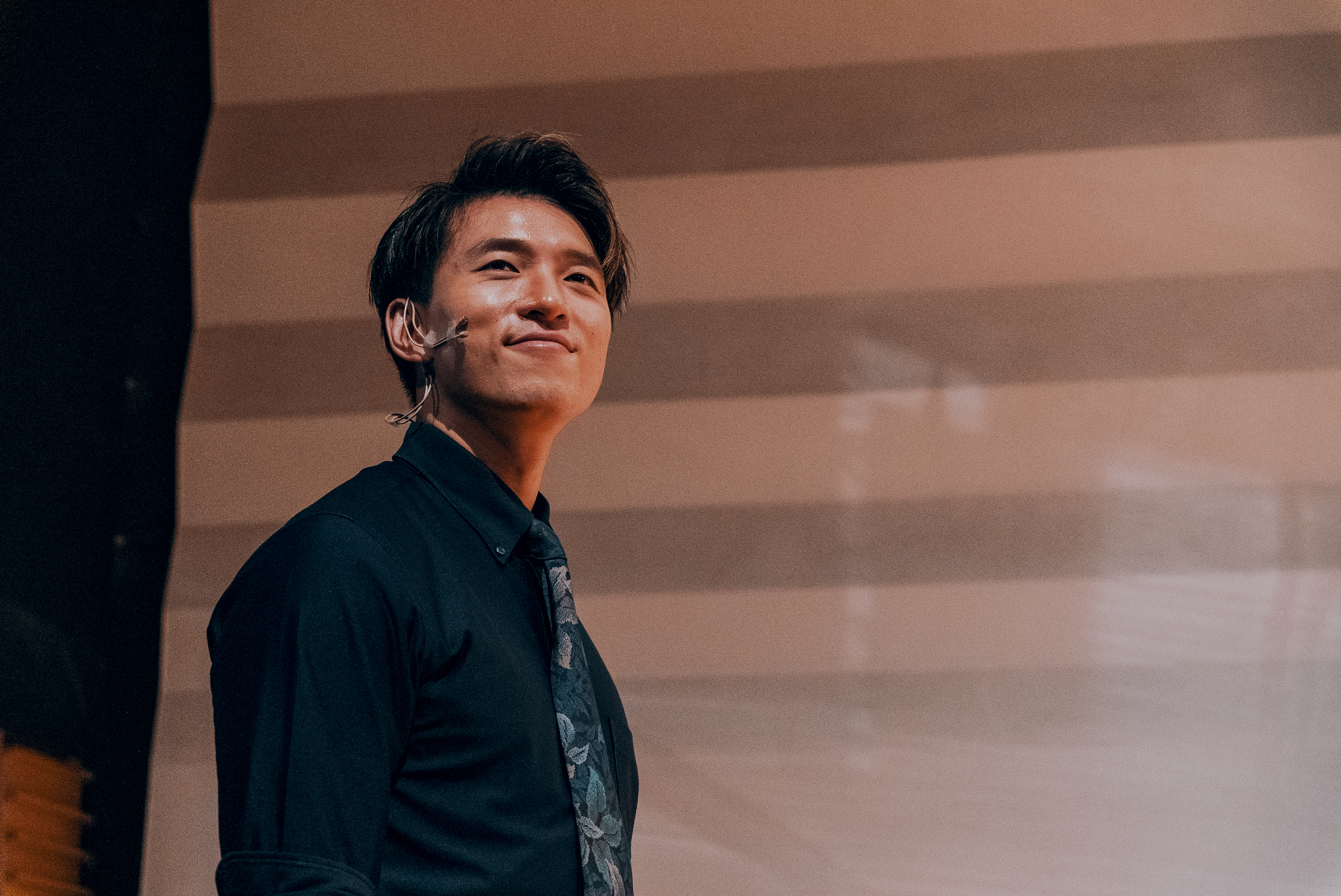 Terrence Leung on stage, wearing a dark suit