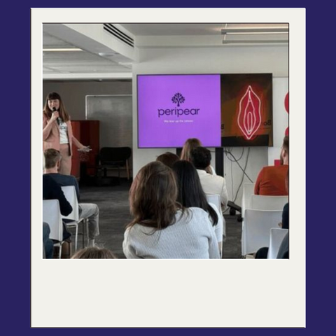 Mujer dando una presentación sobre Peripear a una audiencia sentada