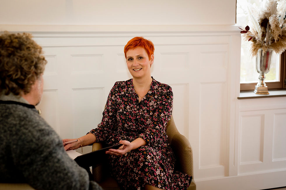 Querformat-Foto von Nadja Müller-Roth im Gespräch mit einer Person, warme natürliche Farben, Fokus auf Nadja, Landschaftsformat.