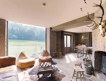 Luxe woonkamer met uitzicht, bruine stoelen en een houten vloer in huis.