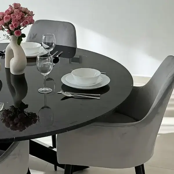 Round glass dining table with grey chairs