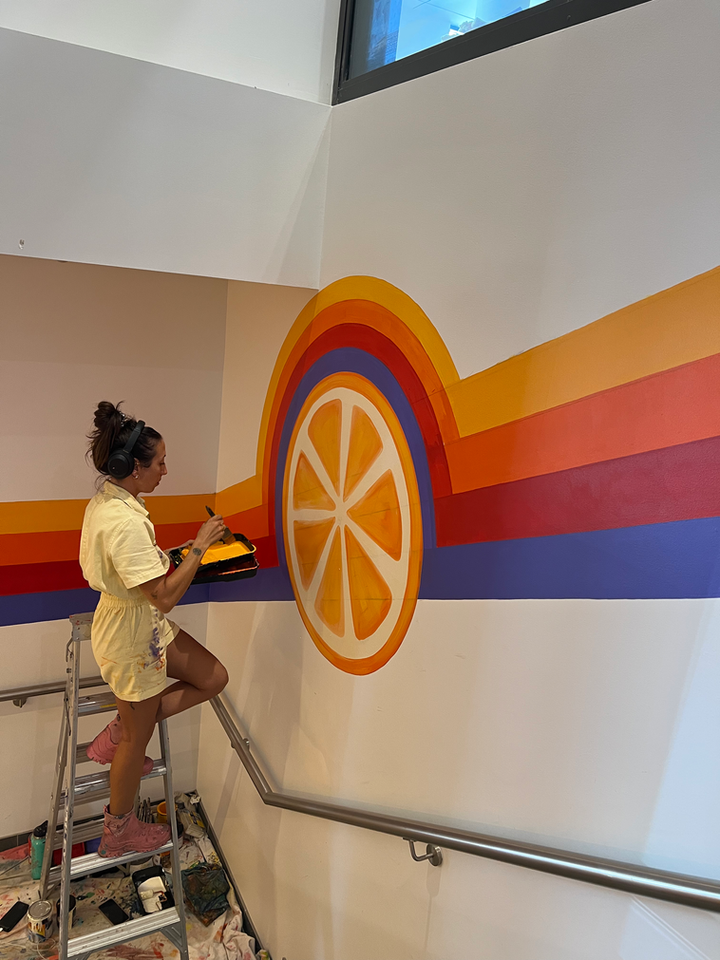 Orange slice and retro line mural painted on stairwell wall at WOTSO Kogarah.