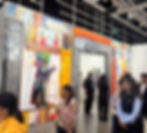 People view colorful abstract artwork on textured walls in a gallery. The setting is lively, with visitors engaged and admiring the art. Art Basel Hong Kong 2025