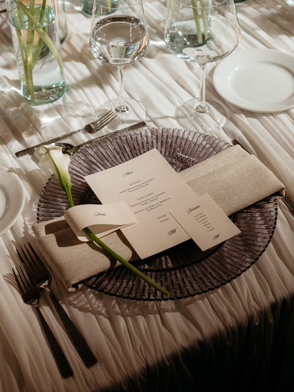 Menu suite and place cards, laid on the charger. Set to be read while seated, not while standing over it.