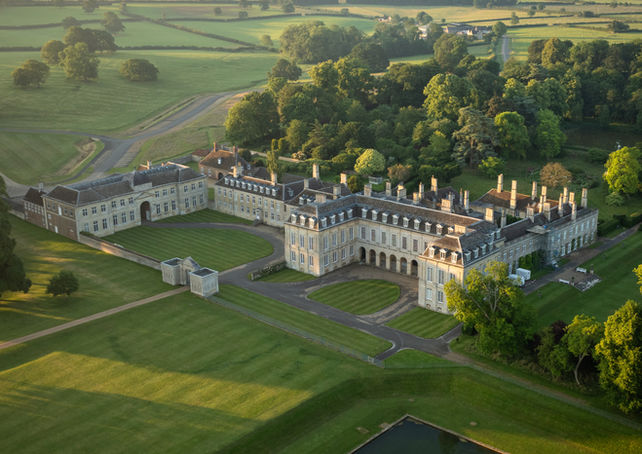 A stunning French inspired country house from above with an orange sky above.