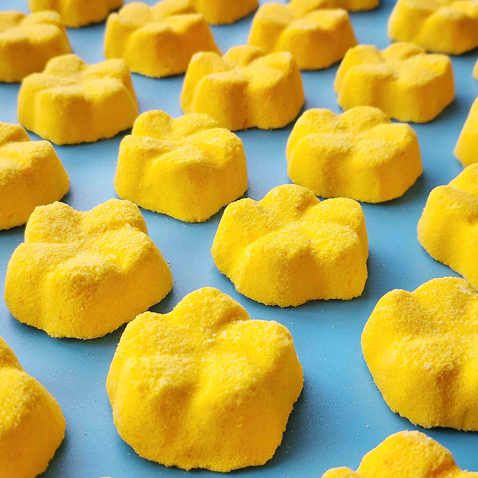 Thumbnail: yellow frangipani shaped bath bombs placed in a neat array on a blue background