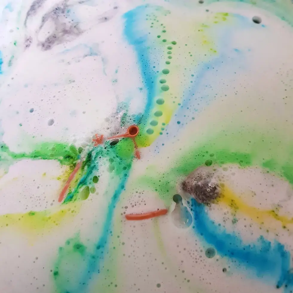 Thumbnail: bath bomb foaming and dissolving releasing blue, yellow, and green streaks of colour
