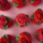 Red circular bath bomb with a rose on top on a pink background