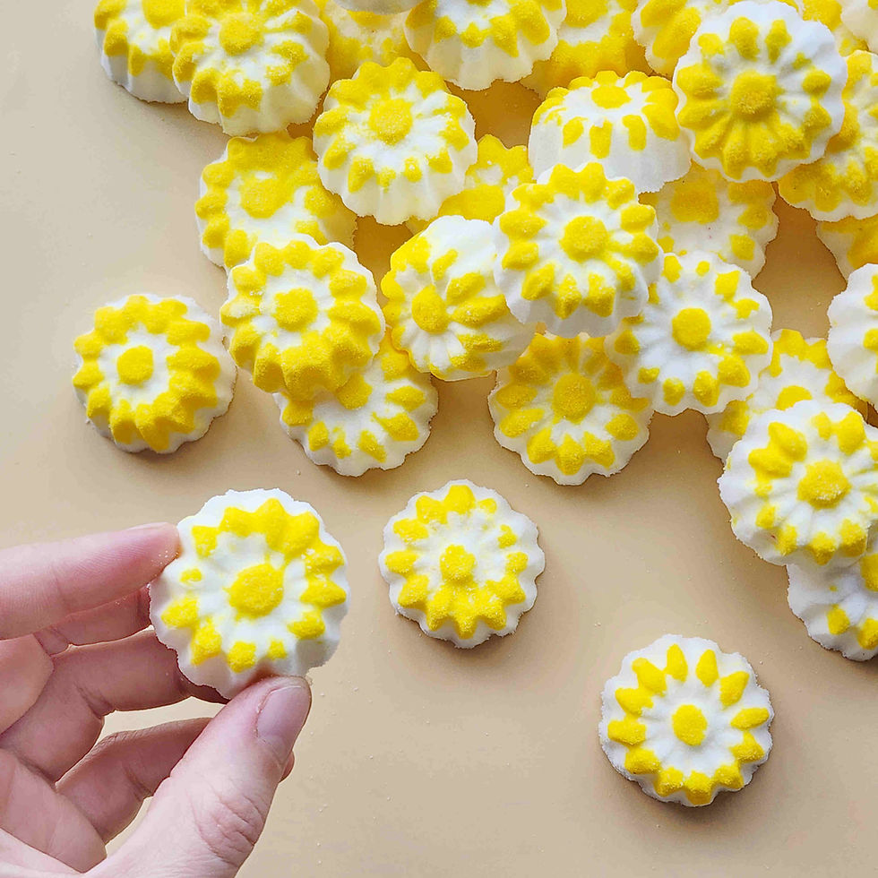 Thumbnail: chamomile shaped mini bath bombs with a white base and yellow detail on a neutral plain background
