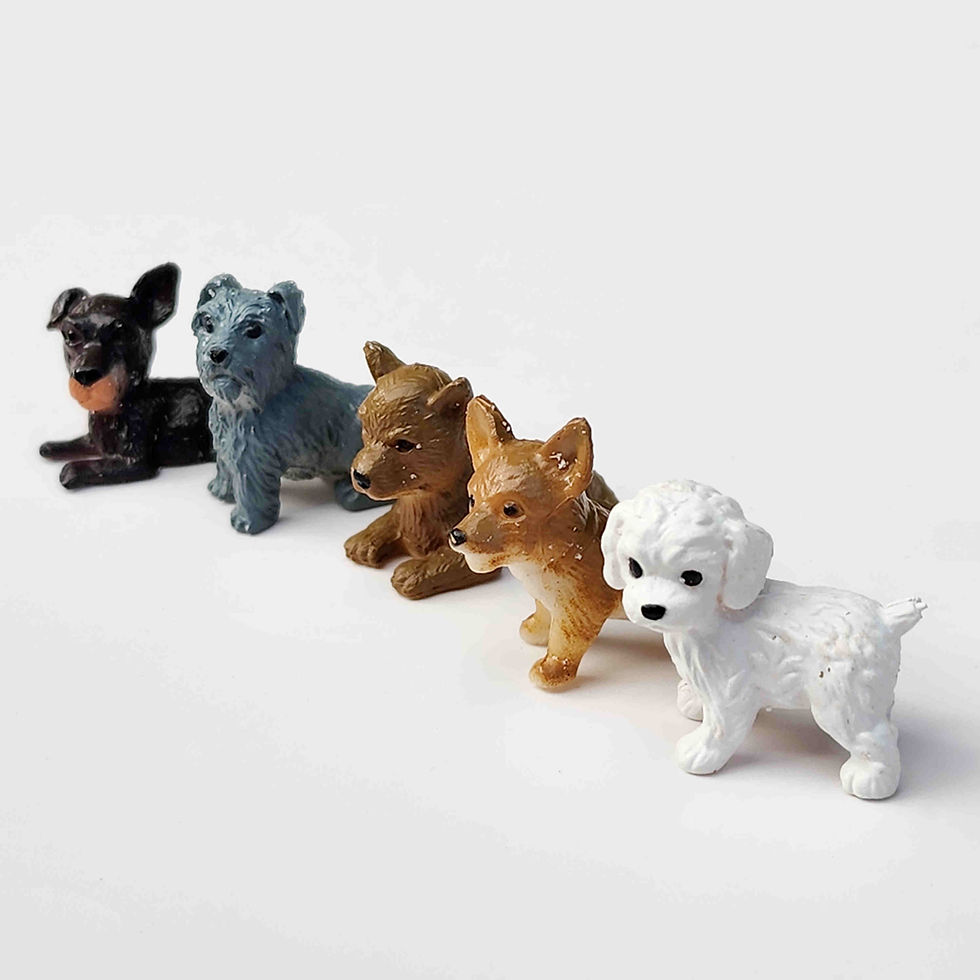 Row of puppy dog figurines lined up in a row on a white background