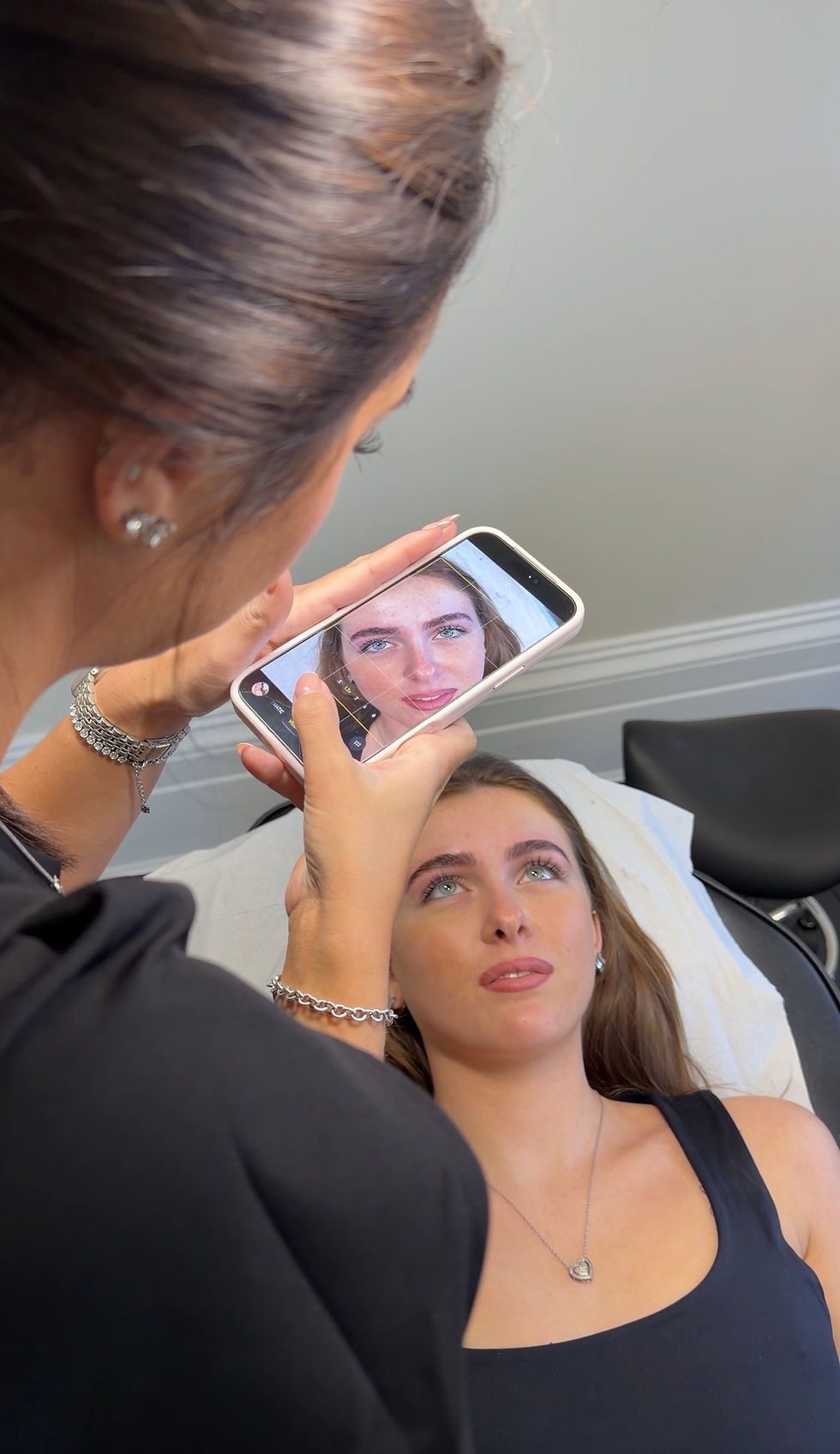 Student performing brow lamination under educator supervision at IMAJ