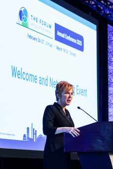 woman speaking at podium at a ForumEA conference