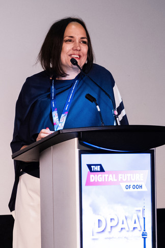 lady smiling and speaking at a podium