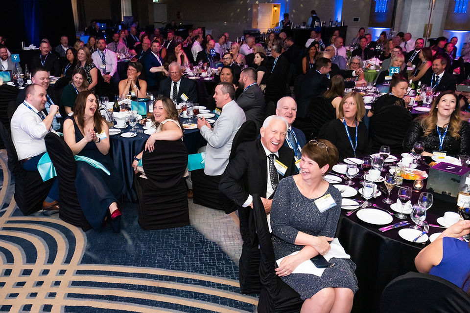 wide shot of audience reacting and laughing to a speaker