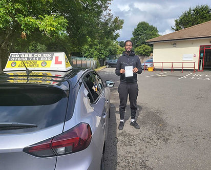 Young man proudly displaying his practical driving test pass certificate
