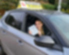 young woman proudly displaying her practical driving test pass certificate