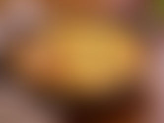 Skillet filled with baked Thanksgiving leftovers topped with golden potatoes and cheese on a wooden table.