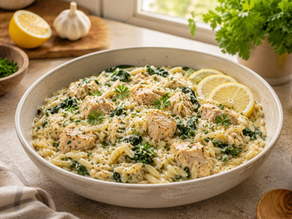 One-pot lemon-orzo chicken served in a ceramic bowl on a kitchen counter, with lemon slices and parsley.