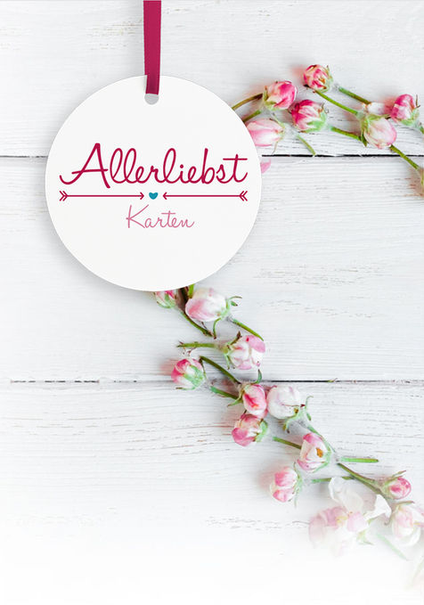 Logo von Allerliebst-Karten auf einem Herzförmigen Blumenkranz. Zarte helle rosa Farben.