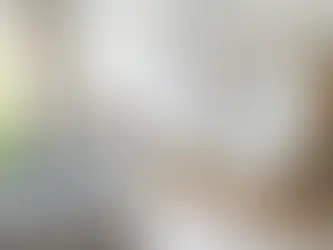 Mulher de pijama deitada na cama procrastinando com relógio grande e calendário ao fundo.