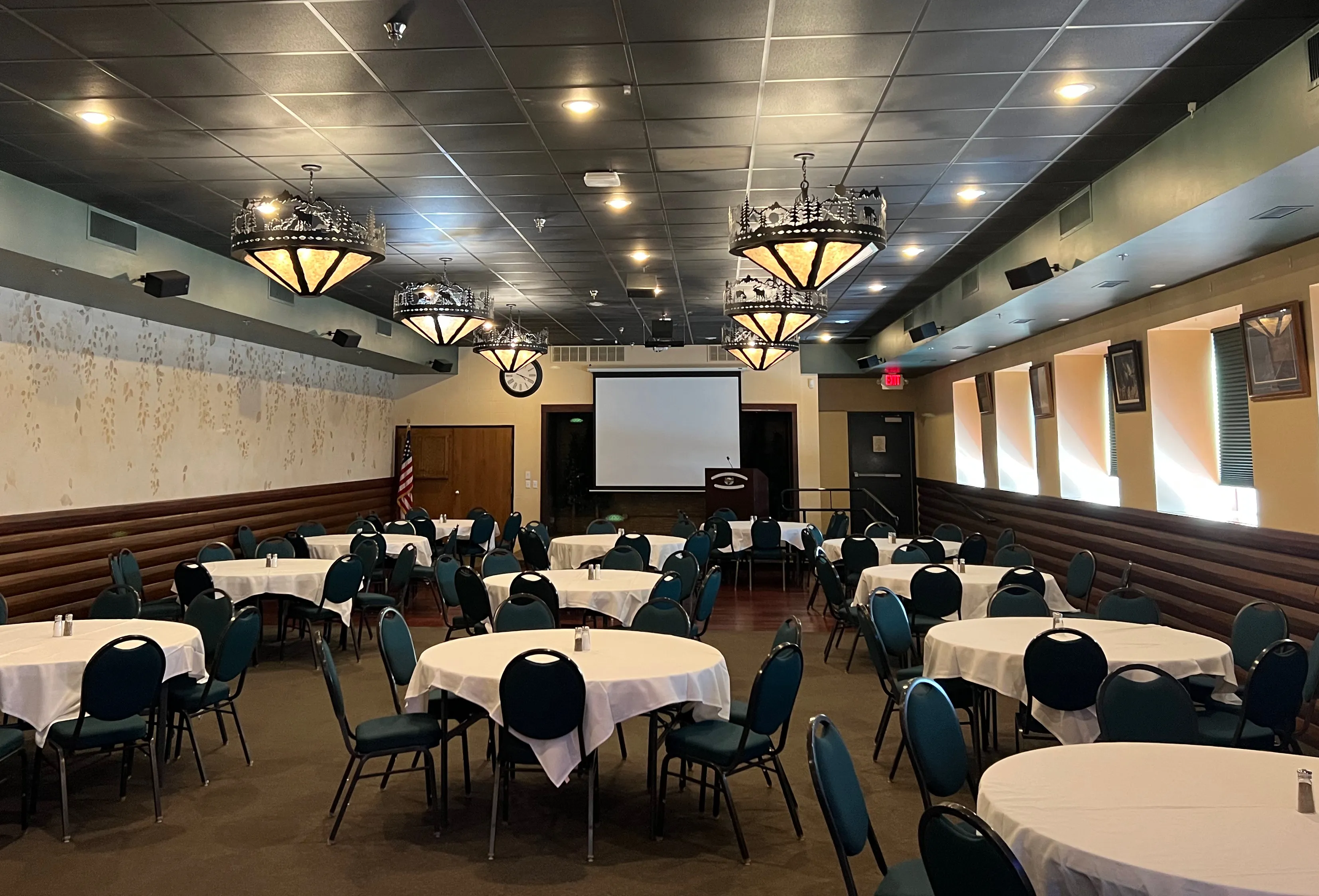 Conference center set up with tables and a projector screen